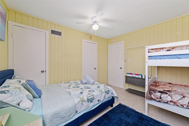 bedroom featuring tile patterned floors, visible vents, and a ceiling fan