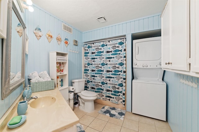 bathroom with a shower with curtain, visible vents, tile patterned flooring, stacked washer and clothes dryer, and toilet