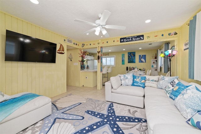 living room featuring light tile patterned flooring, visible vents, and ceiling fan