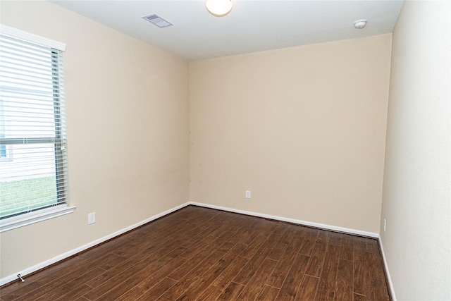 unfurnished room featuring visible vents, baseboards, and wood finished floors