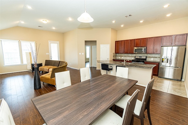 dining space featuring visible vents, baseboards, light wood-type flooring, vaulted ceiling, and recessed lighting