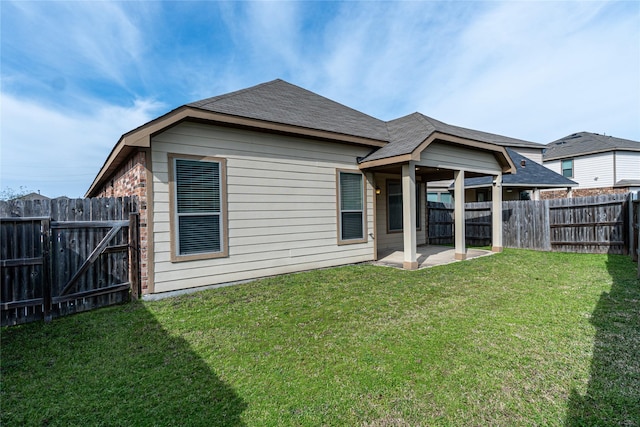 back of house featuring a lawn, a gate, a fenced backyard, roof with shingles, and a patio area