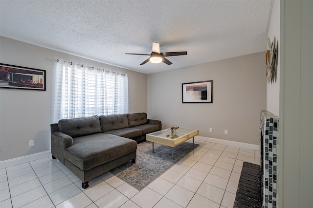 living area featuring light tile patterned flooring, baseboards, a textured ceiling, and ceiling fan