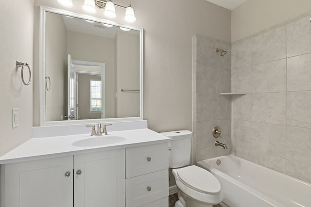 full bath with visible vents, toilet, bathing tub / shower combination, a textured wall, and vanity