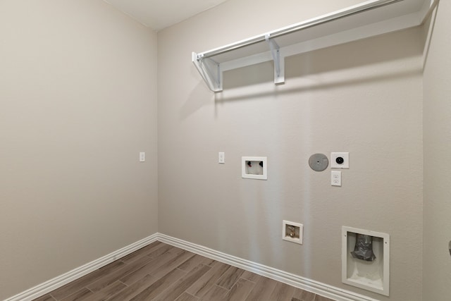 washroom with washer hookup, dark wood finished floors, hookup for an electric dryer, gas dryer hookup, and laundry area