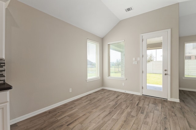 interior space with visible vents, plenty of natural light, lofted ceiling, and light wood finished floors