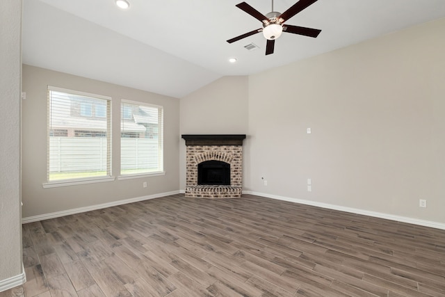 unfurnished living room with wood finished floors, baseboards, a brick fireplace, ceiling fan, and vaulted ceiling