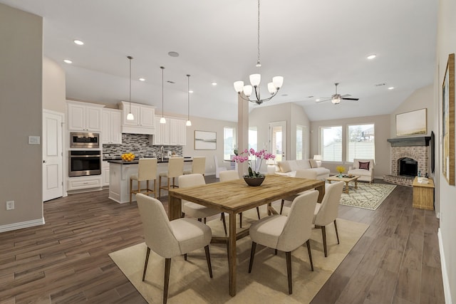 dining area featuring dark wood-style floors, recessed lighting, and a brick fireplace