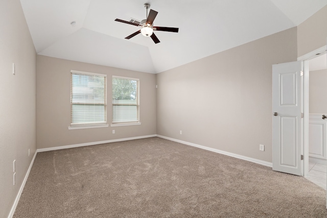 carpeted empty room featuring baseboards, ceiling fan, and vaulted ceiling