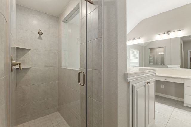 full bath featuring vanity, vaulted ceiling, a stall shower, and tile patterned floors