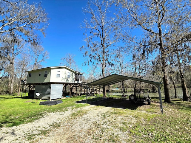 view of side of home with a detached carport, a lawn, and driveway