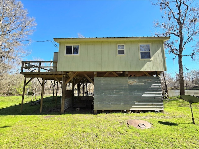 exterior space with stairway, a lawn, and metal roof