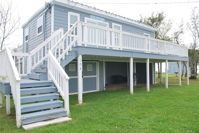 rear view of house with stairs, a yard, metal roof, and a wooden deck