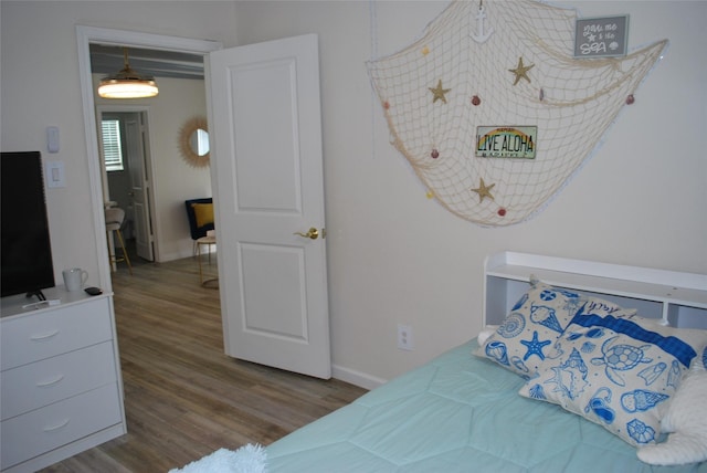 bedroom featuring wood finished floors and baseboards