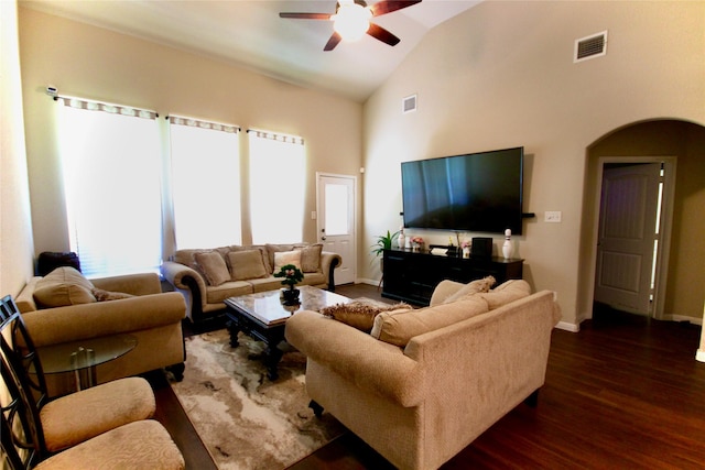 living area with dark wood-style floors, arched walkways, visible vents, and baseboards