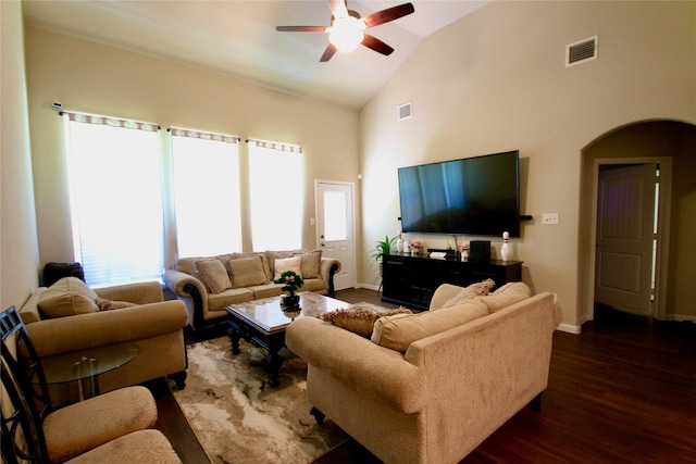 living area featuring dark wood-style floors, visible vents, baseboards, arched walkways, and ceiling fan