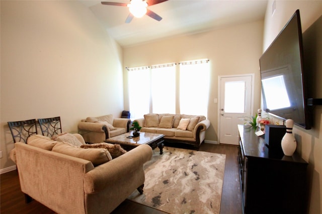 living room with a wealth of natural light, dark wood-type flooring, and baseboards