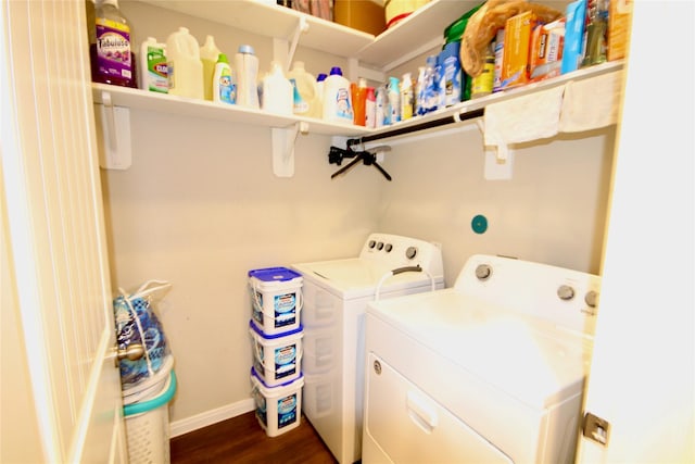 laundry room with washing machine and clothes dryer, laundry area, dark wood-type flooring, and baseboards