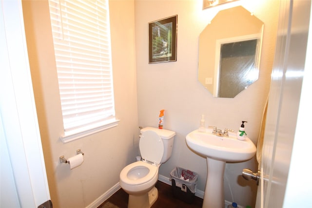 half bathroom featuring baseboards and toilet