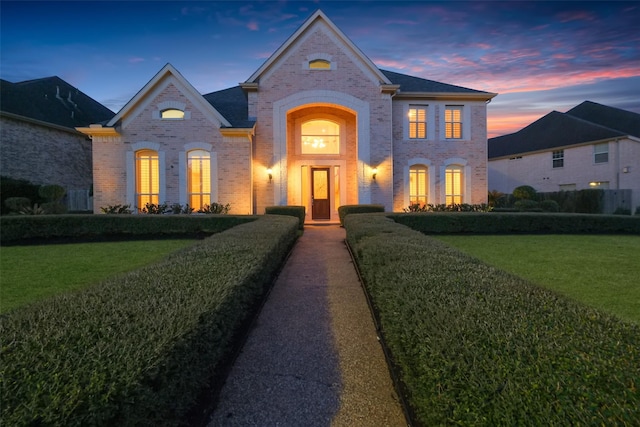 view of front of property featuring a front lawn and brick siding