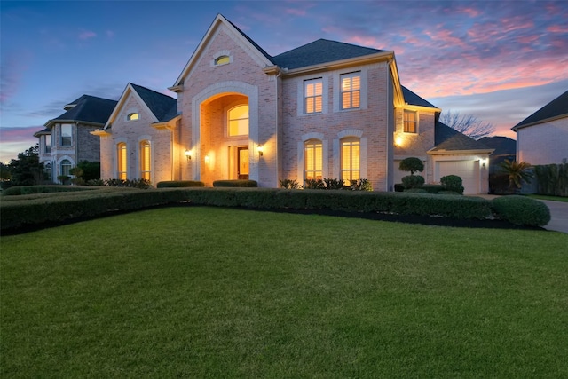 view of front of home with driveway, brick siding, and a front lawn