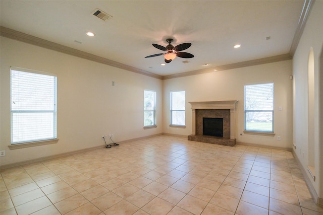 unfurnished living room featuring a fireplace with raised hearth, baseboards, ceiling fan, ornamental molding, and light tile patterned floors