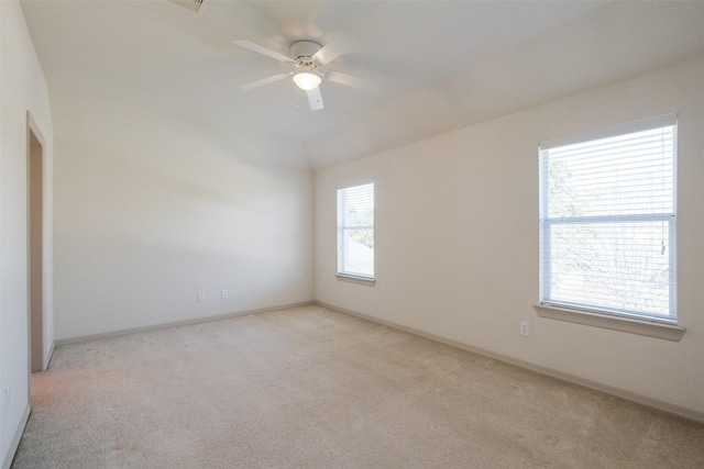 unfurnished room featuring baseboards, light colored carpet, and a ceiling fan