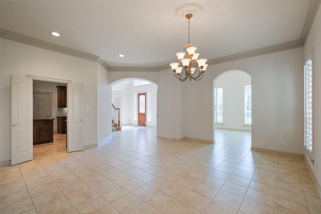 empty room featuring baseboards, ornamental molding, light tile patterned floors, an inviting chandelier, and arched walkways