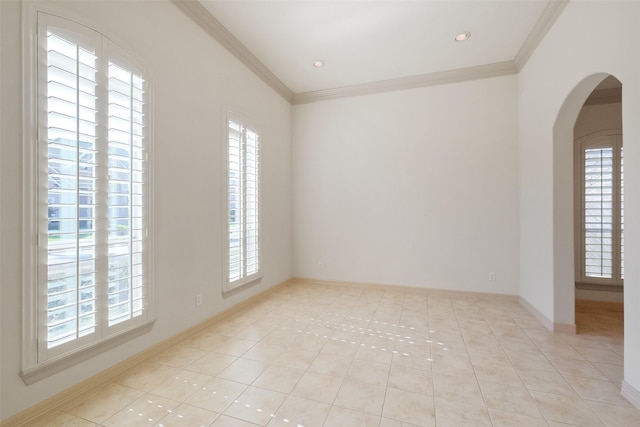 spare room featuring crown molding, a healthy amount of sunlight, and arched walkways