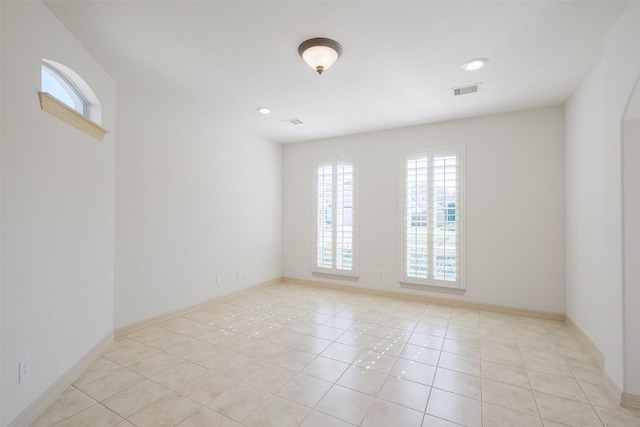 unfurnished room with light tile patterned floors, baseboards, and visible vents