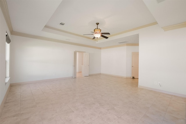 spare room with visible vents, baseboards, ceiling fan, ornamental molding, and a raised ceiling