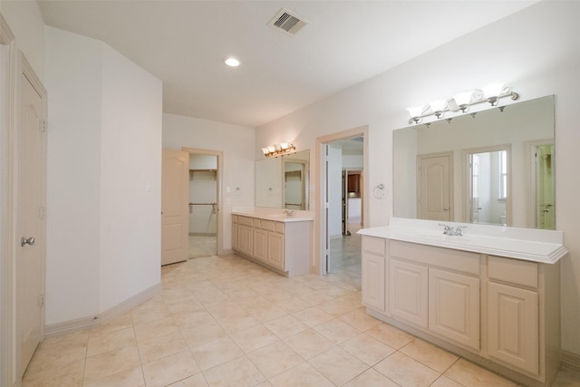 bathroom with tile patterned flooring, visible vents, a sink, and two vanities