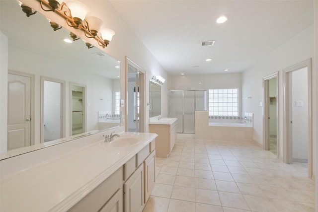 full bathroom featuring tile patterned floors, visible vents, a garden tub, two vanities, and a sink