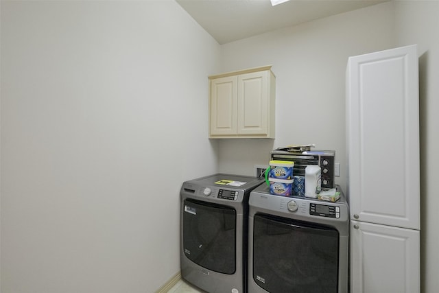 laundry room featuring baseboards, cabinet space, and washer and clothes dryer