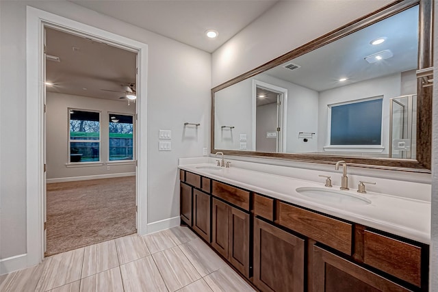 full bath featuring double vanity, visible vents, a shower with shower door, and a sink