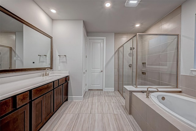 full bath with vanity, baseboards, recessed lighting, a stall shower, and a garden tub