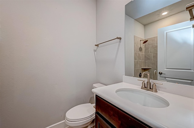 bathroom with baseboards, toilet, vanity, and walk in shower