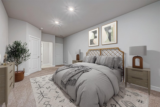 bedroom with light carpet, visible vents, and baseboards