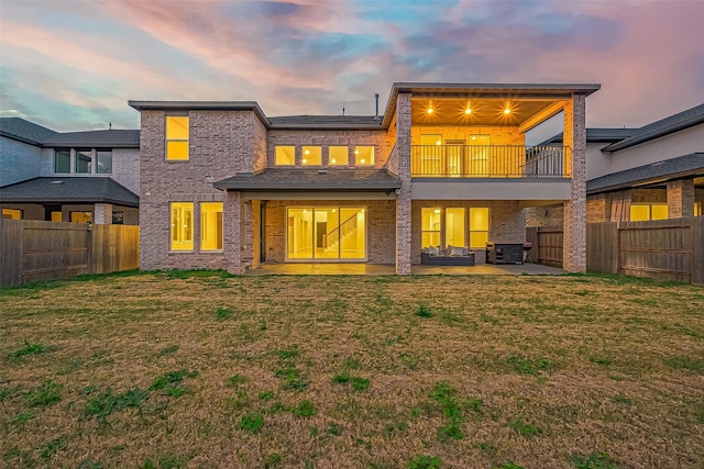 rear view of house featuring a lawn, a fenced backyard, cooling unit, a balcony, and a patio area