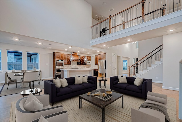 living area featuring stairway, recessed lighting, light wood-style floors, and baseboards