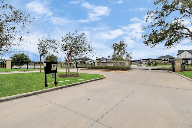 view of street featuring a gate, curbs, and a gated entry