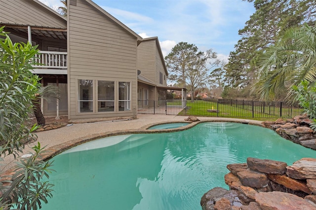 view of pool with an in ground hot tub and fence