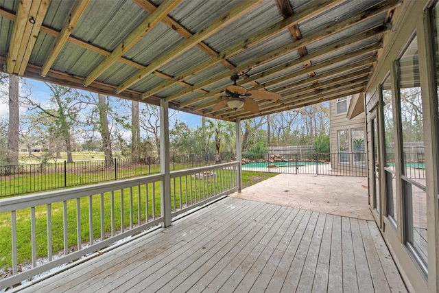 wooden terrace with a ceiling fan, a fenced in pool, a fenced backyard, a patio area, and a lawn