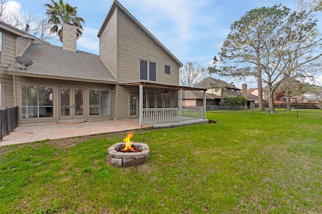 rear view of house featuring an outdoor fire pit, a yard, a fenced backyard, a shingled roof, and a patio area