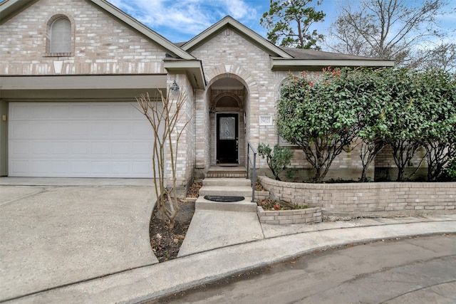 view of front of home featuring brick siding, concrete driveway, and an attached garage