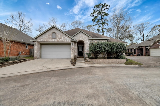 view of front of house featuring brick siding, concrete driveway, a garage, and roof with shingles