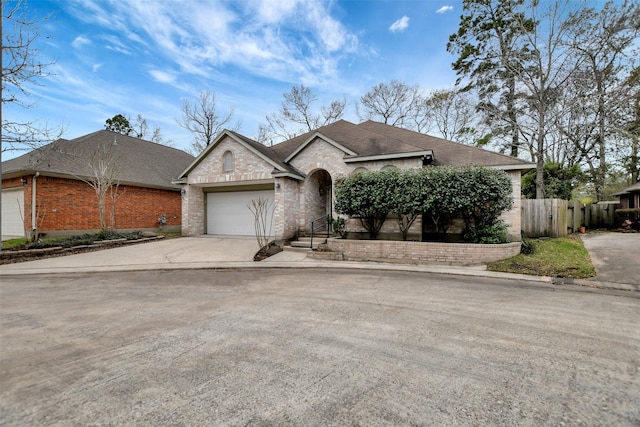 view of front of property featuring brick siding, fence, concrete driveway, roof with shingles, and an attached garage