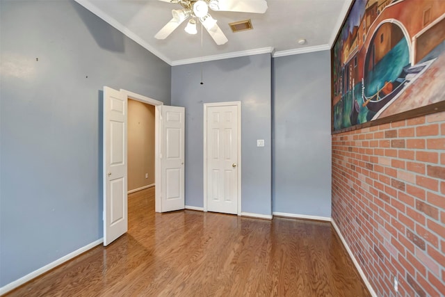 unfurnished bedroom featuring wood finished floors, visible vents, and ornamental molding