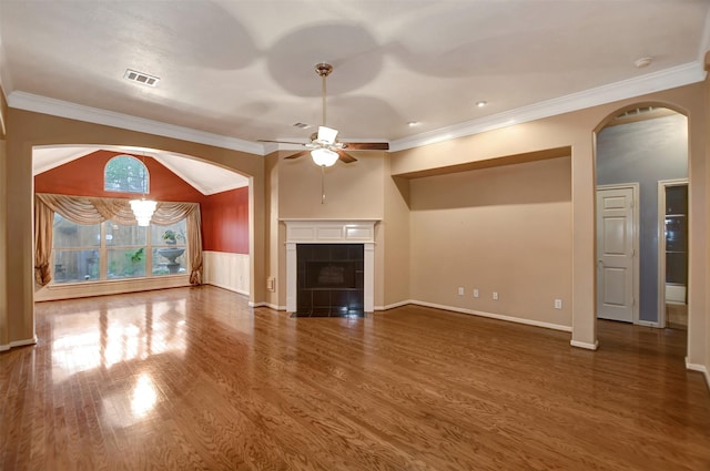 unfurnished living room featuring visible vents, crown molding, ceiling fan, wood finished floors, and arched walkways