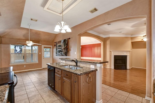 kitchen featuring open floor plan, black dishwasher, light tile patterned floors, ceiling fan with notable chandelier, and a sink